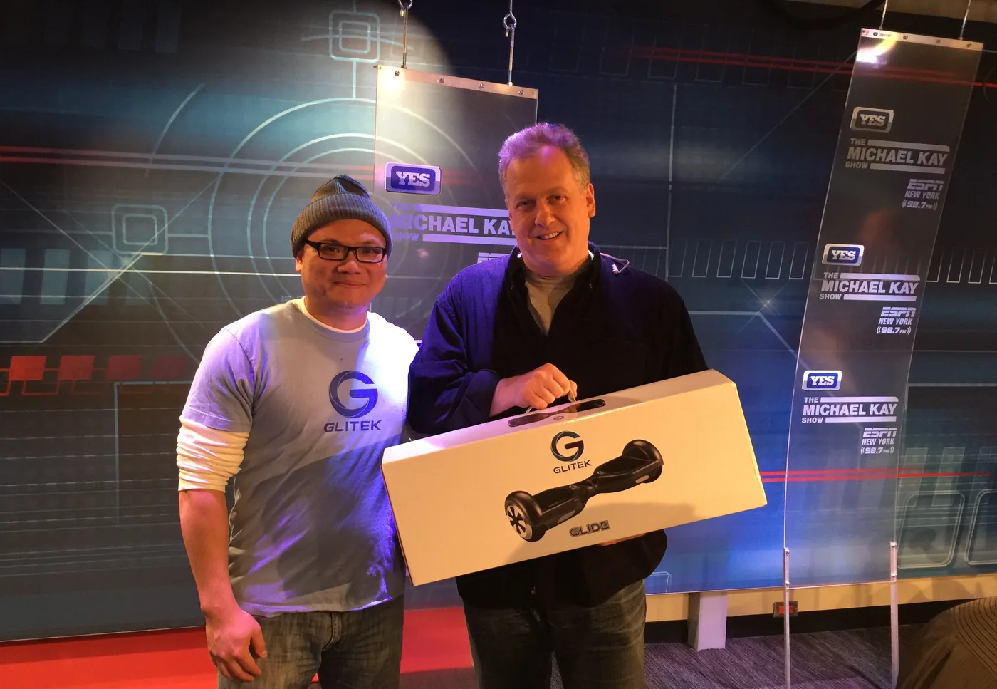Tony Le with Michael Kay, who is holding a Glitek Glide, on the YES Network set